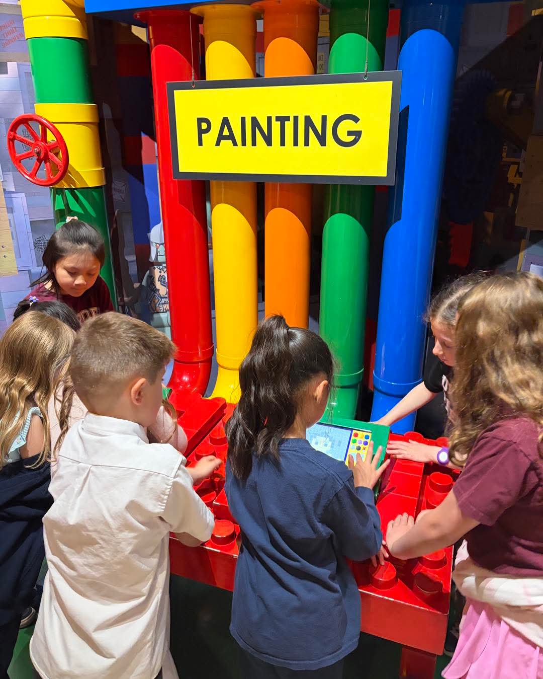 Students exploring a colorful painting exhibit on a field trip