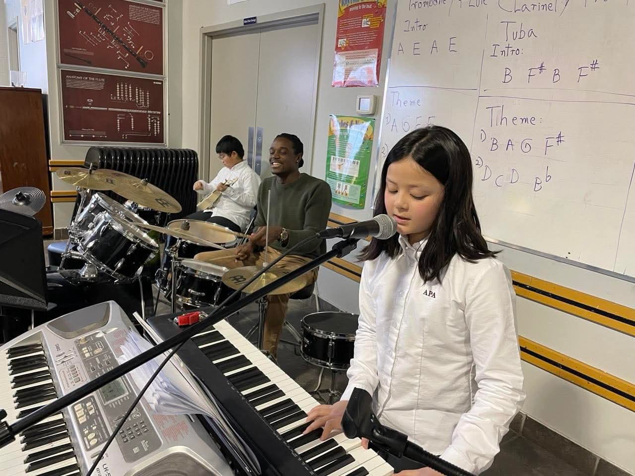 Student singing at keyboard microphone during music class